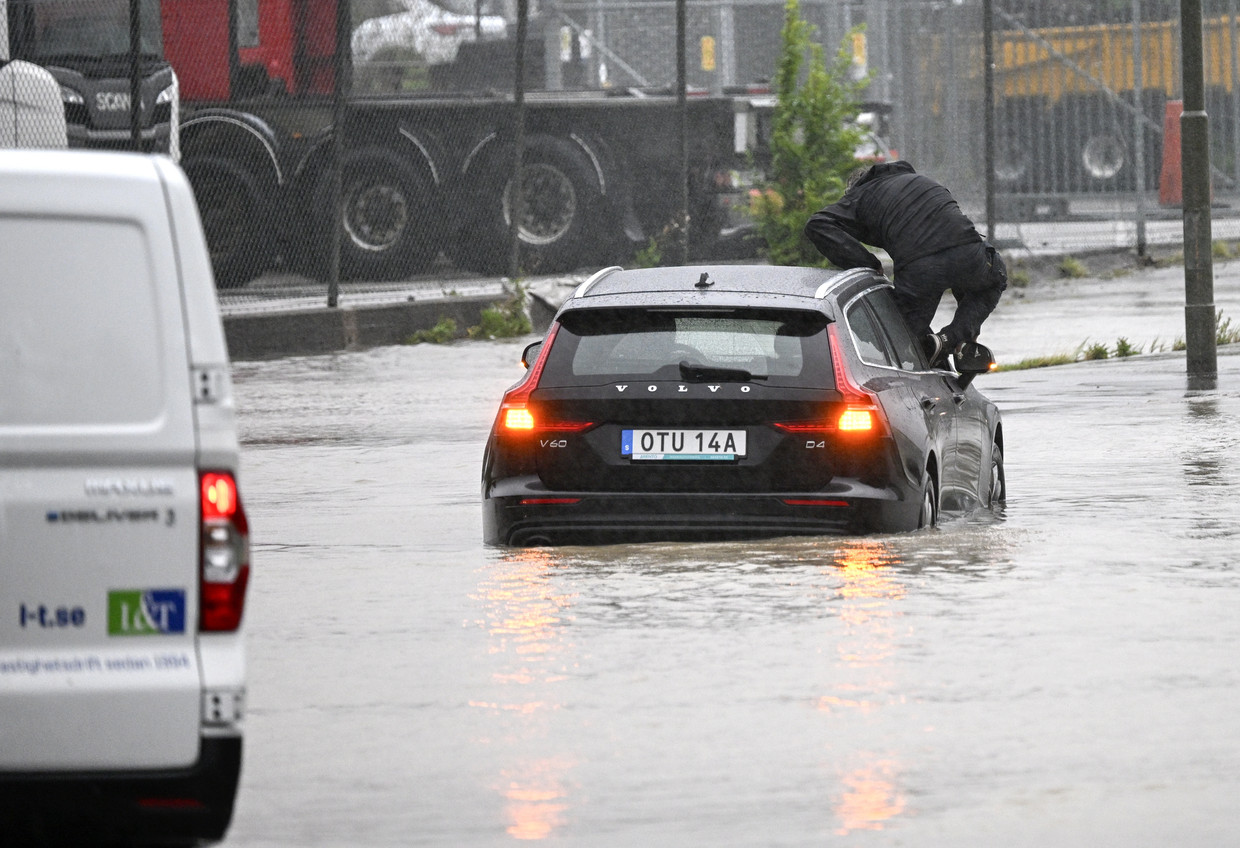     Un uomo esce da un'auto sommersa ad Arlov, vicino a Malmö, in Svezia.  Immagine ANP/EPA