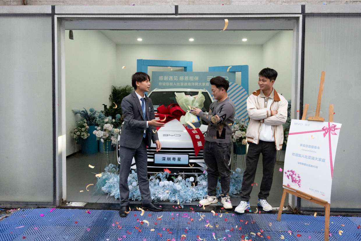 The purchase of a BYD electric car is celebrated at a car dealer in Shenzhen on January 29.  Photo by Jill Sabry/The New York Times