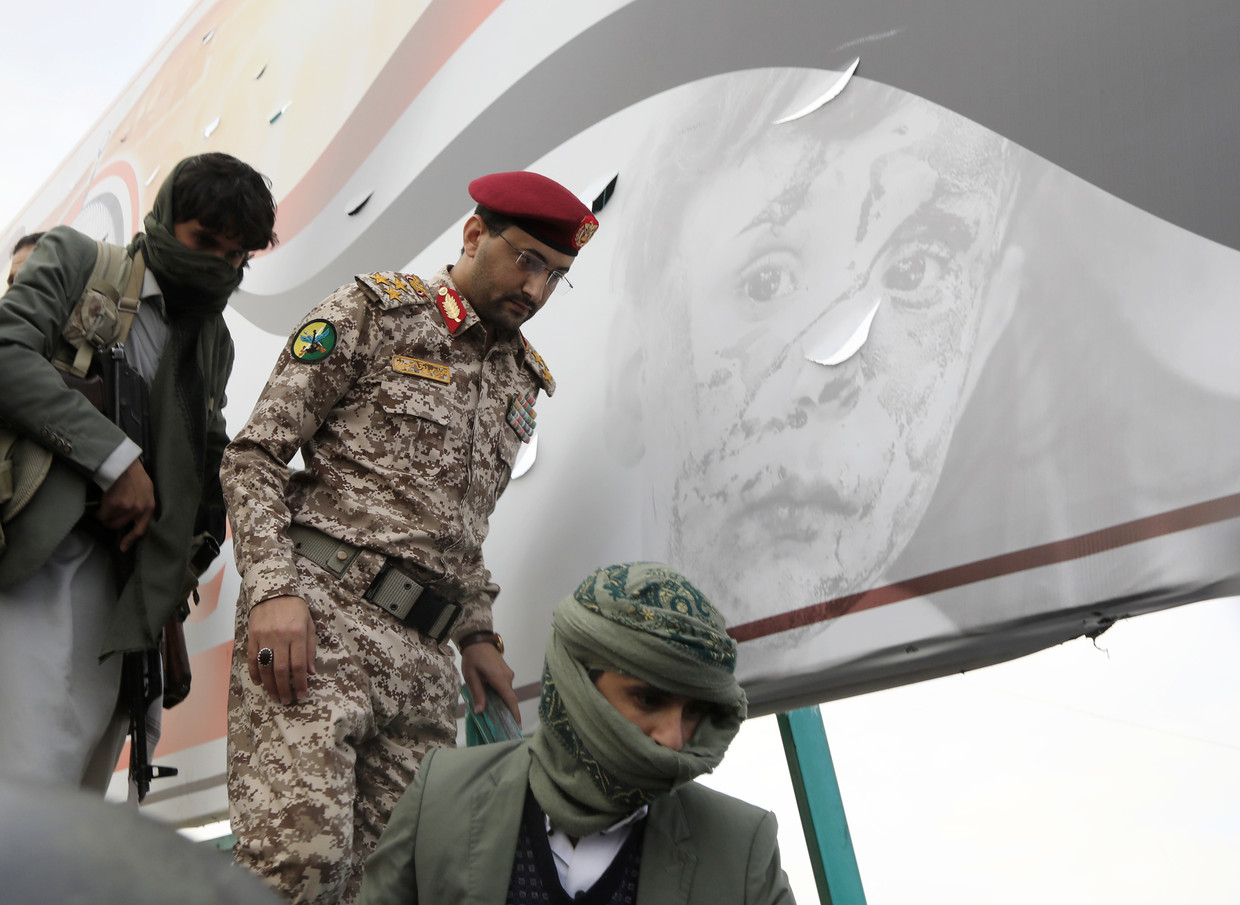 De militaire woordvoerder van de Houthi's, Yahya Saree, (midden) na het afleggen van een militaire verklaring over aanvallen op twee schepen in de Rode Zee.  Beeld ANP / EPA