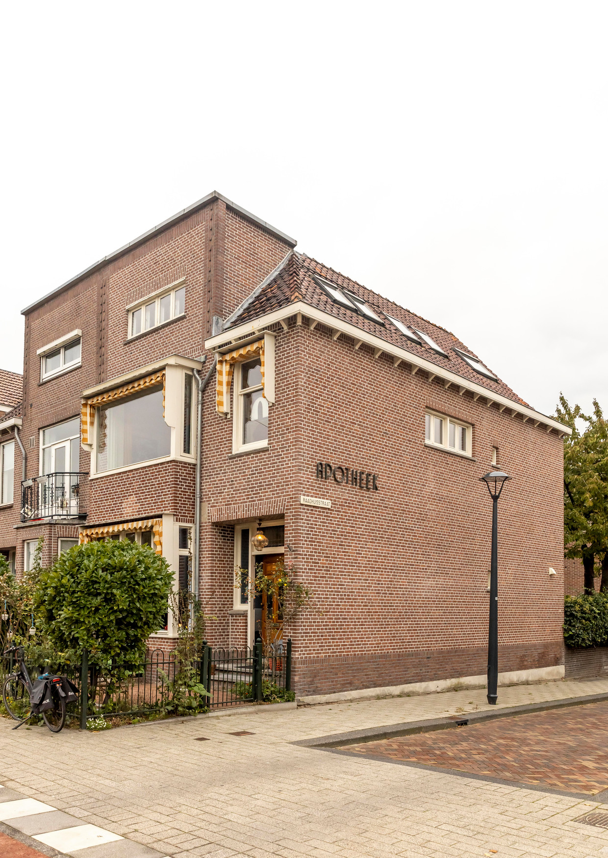 The green awnings on the windows of the former chemist's house have been replaced with yellow awnings that better match the stained glass windows.  Photo by Hennie van Belkom