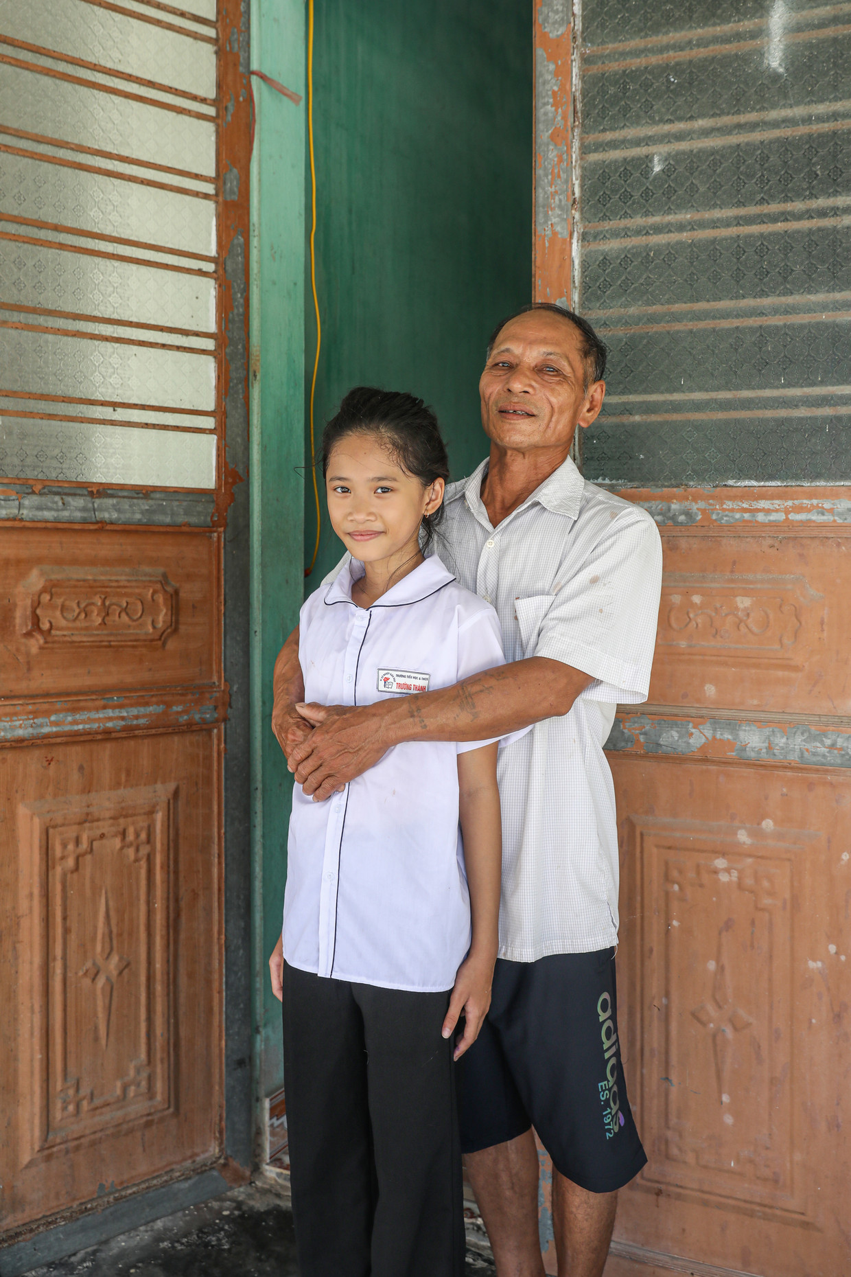Nguyễn Văn Tình (65) met zijn kleinkind Han. Beeld Hendra Eka voor de Volkskrant